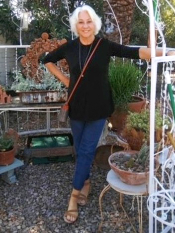 Joanne Allen surrounded by potted plants.